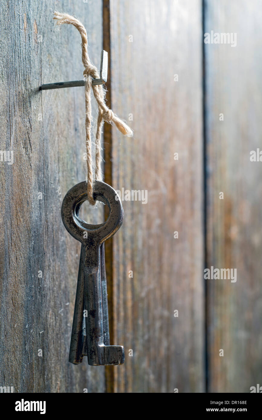 old keys tied with string and hanging from a spike Stock Photo Alamy
