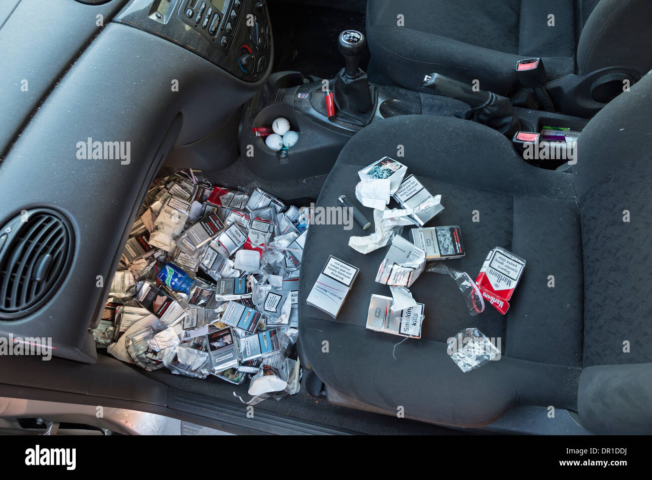 MANY DISCARDED CIGARETTE PACKETS THROWN ON THE FLOOR OF A FORD FOCUS CAR, BY A SMOKER. Stock Photo