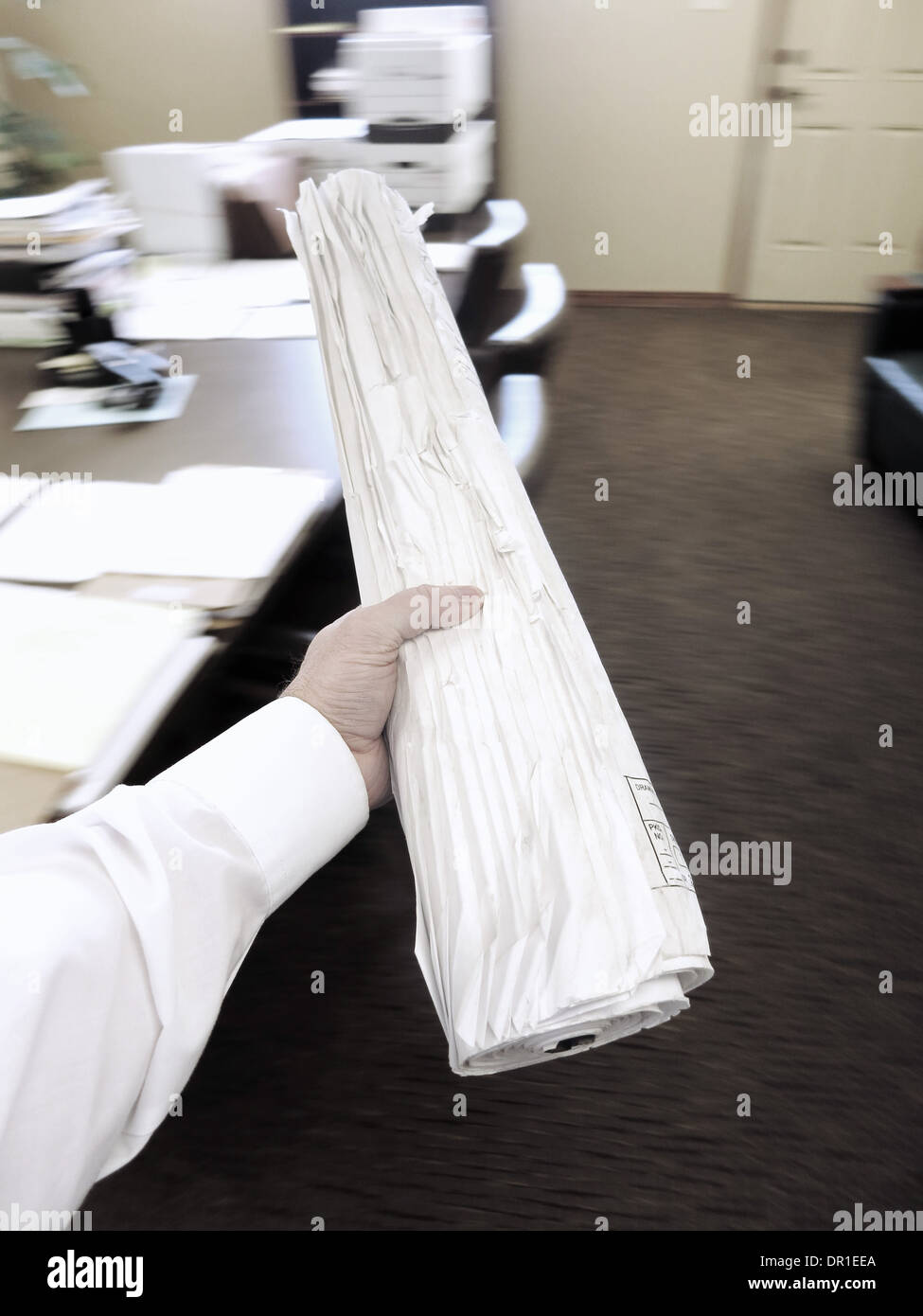 Businessman in office holding roll of drawings Stock Photo