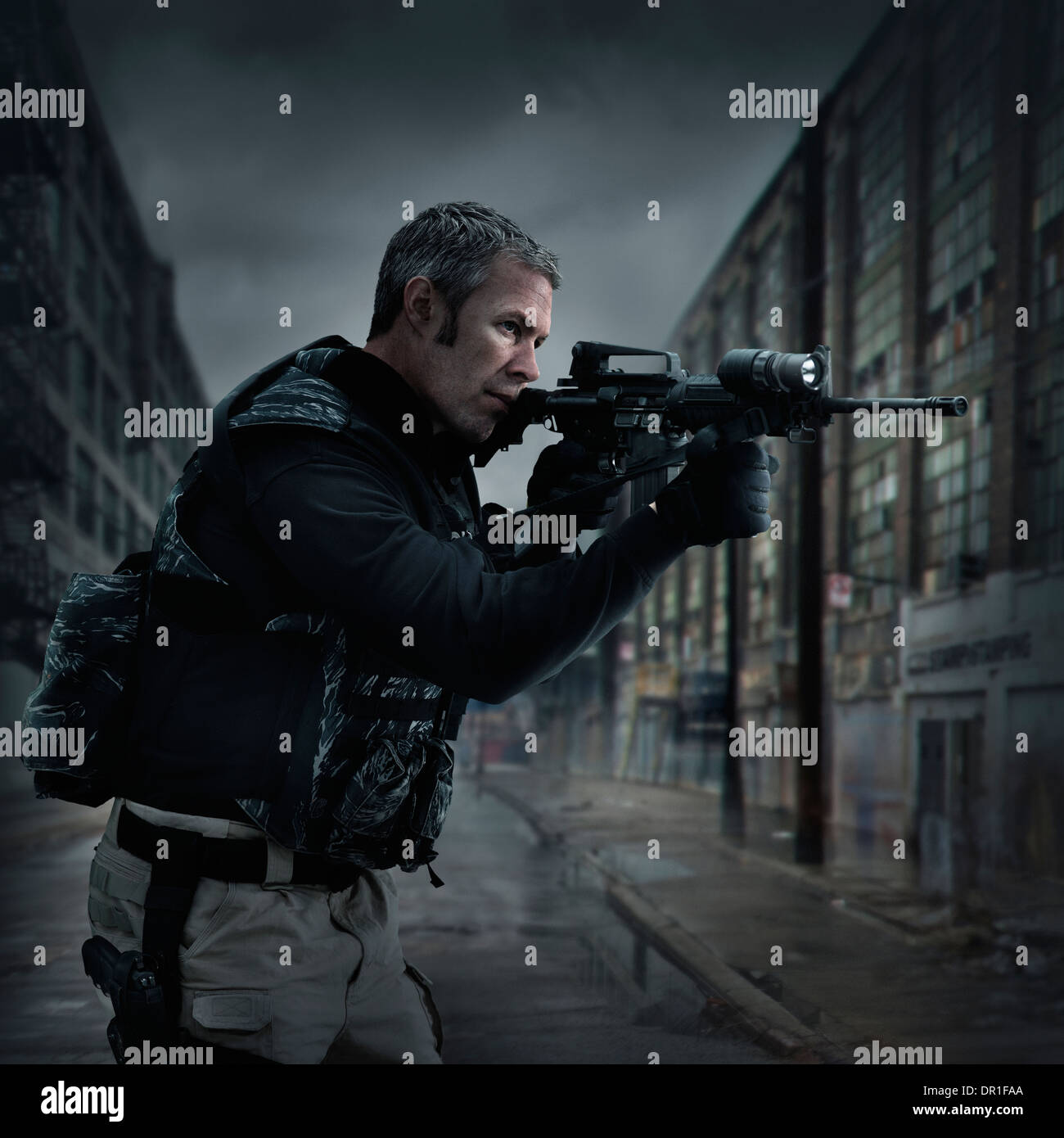 Caucasian sniper aiming gun on city street Stock Photo