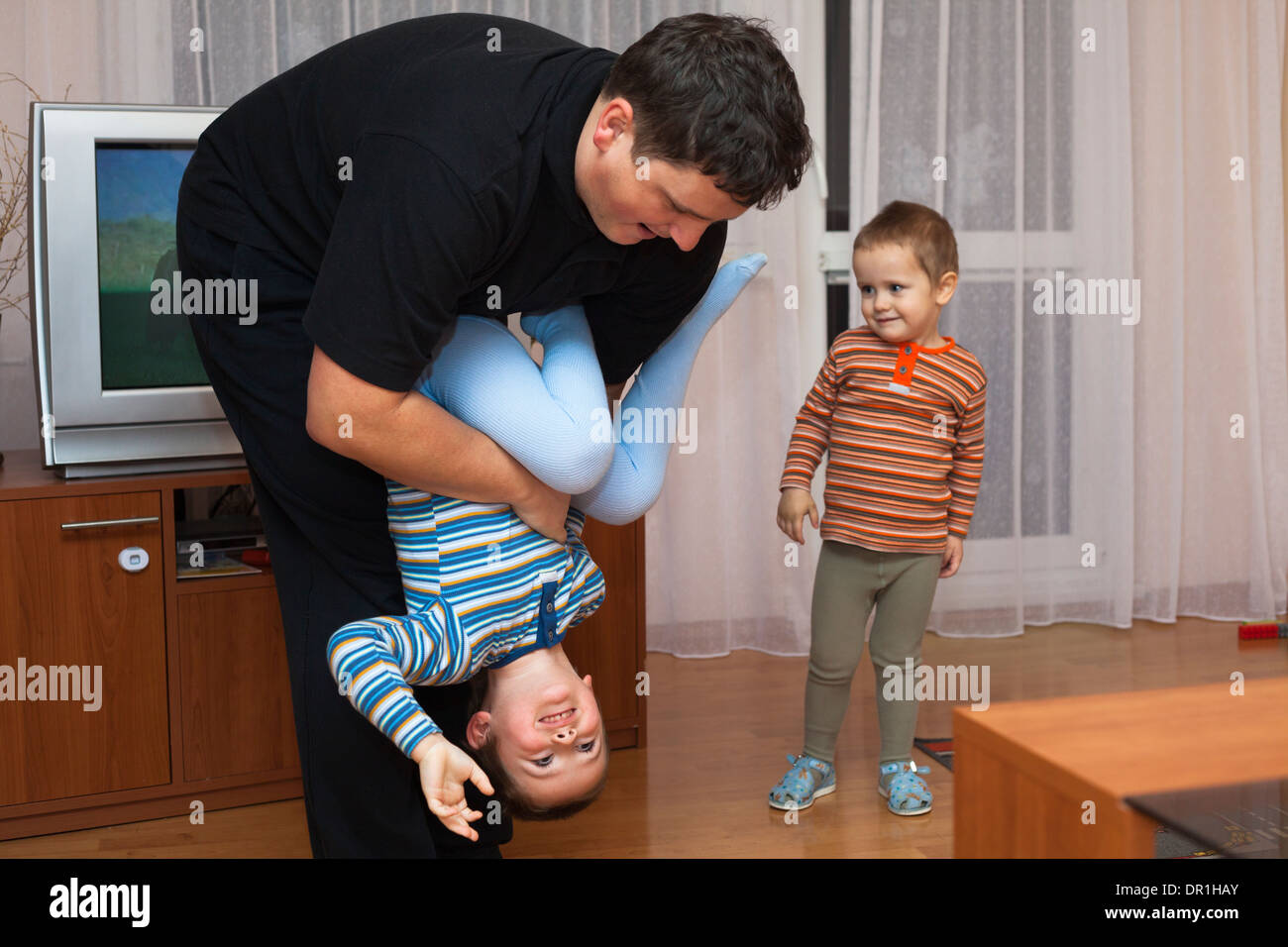 Happy father playing with his child boy at home Stock Photo