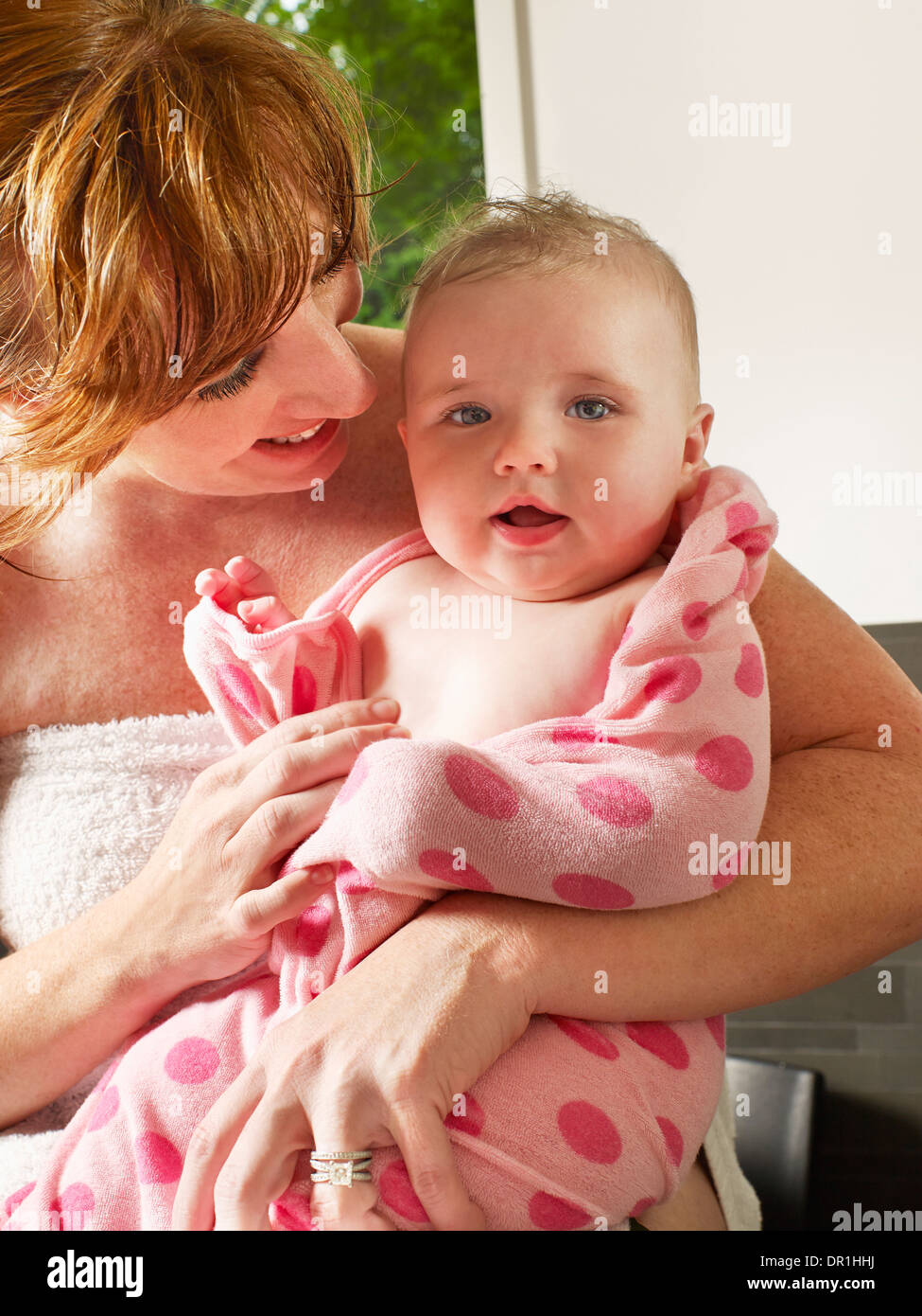 Mother wrapping baby girl in towel Stock Photo Alamy