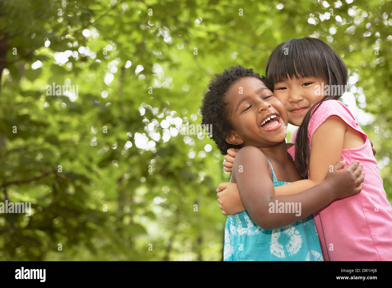 Girls hugging outdoors Stock Photo - Alamy