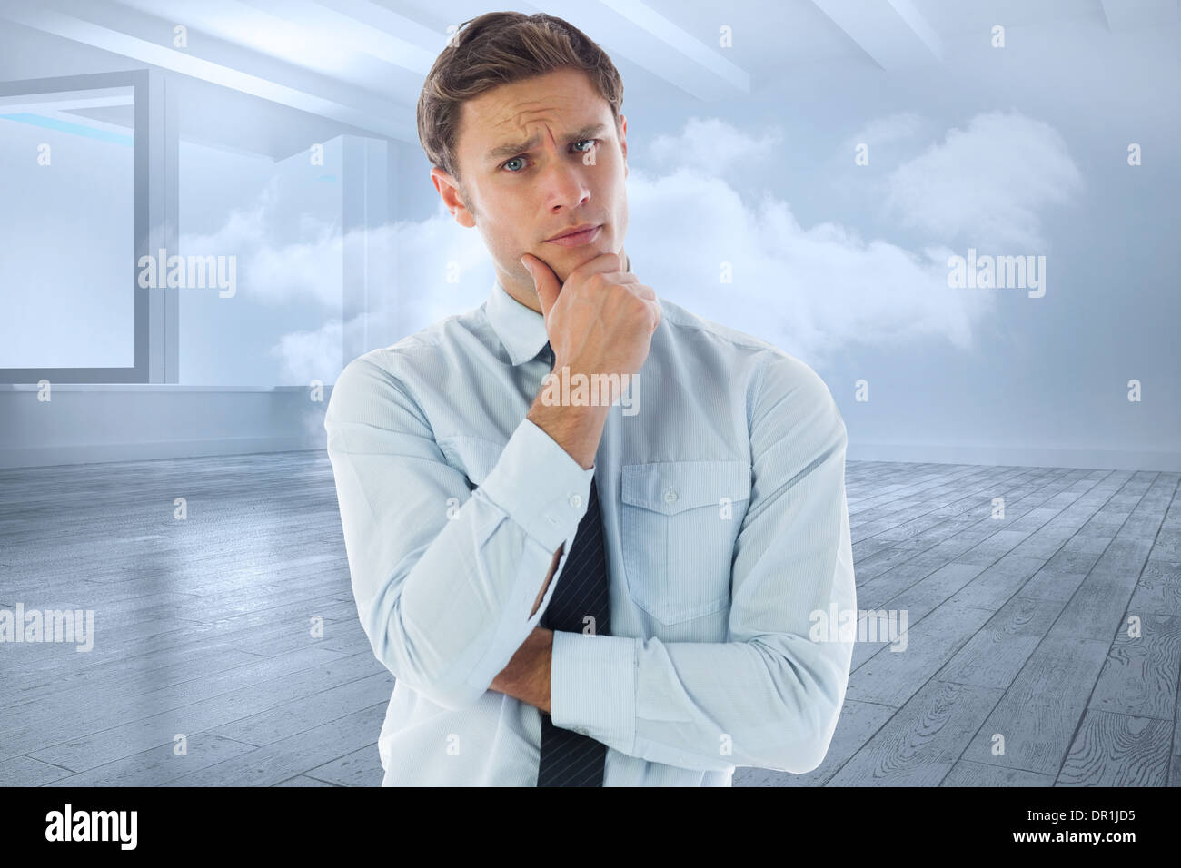 Composite image of thinking businessman with hand on chin Stock Photo