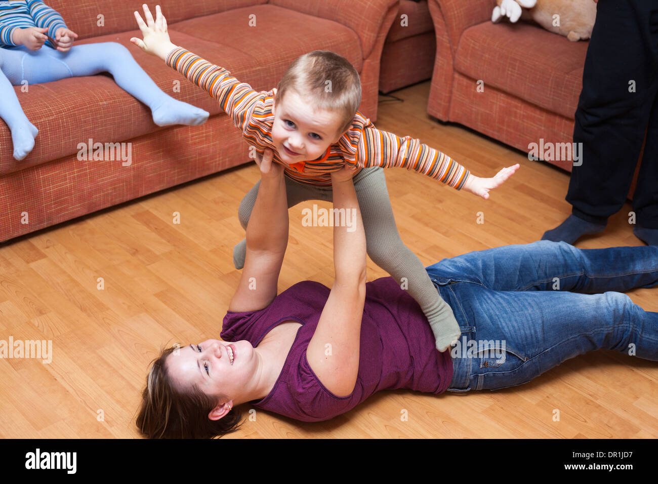 Happy parents playing with children at home Stock Photo