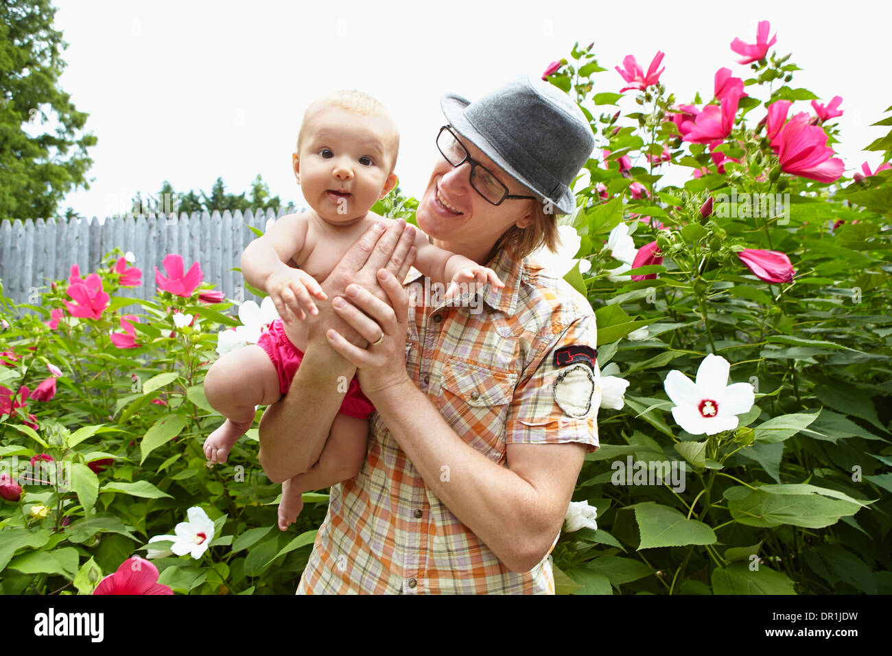 Father carrying baby daughter in park Stock Photo