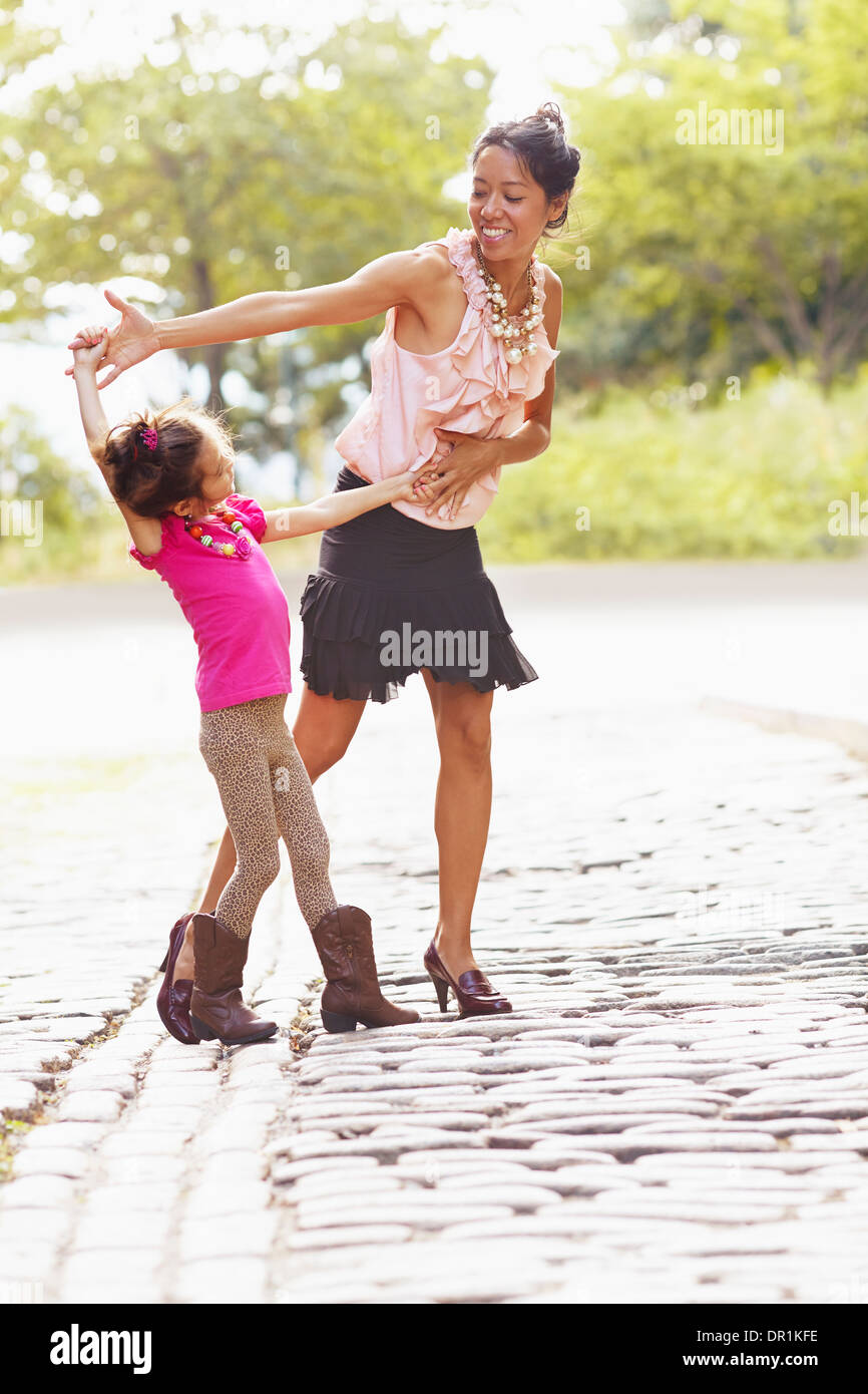 Mother and daughter posing on city street Stock Photo