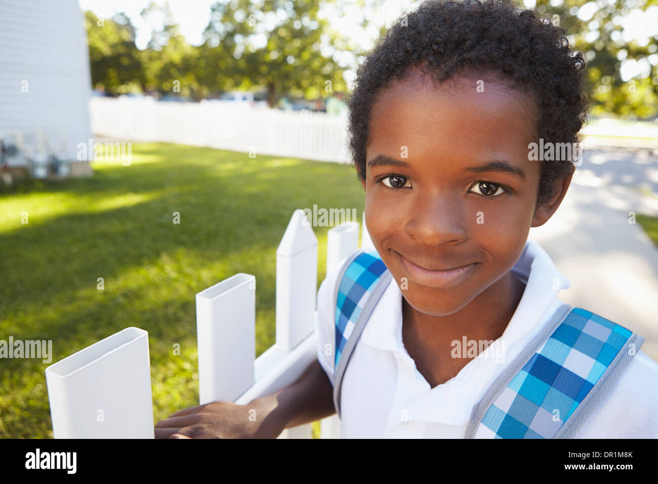 Mixed race boy smiling on suburban street Stock Photo