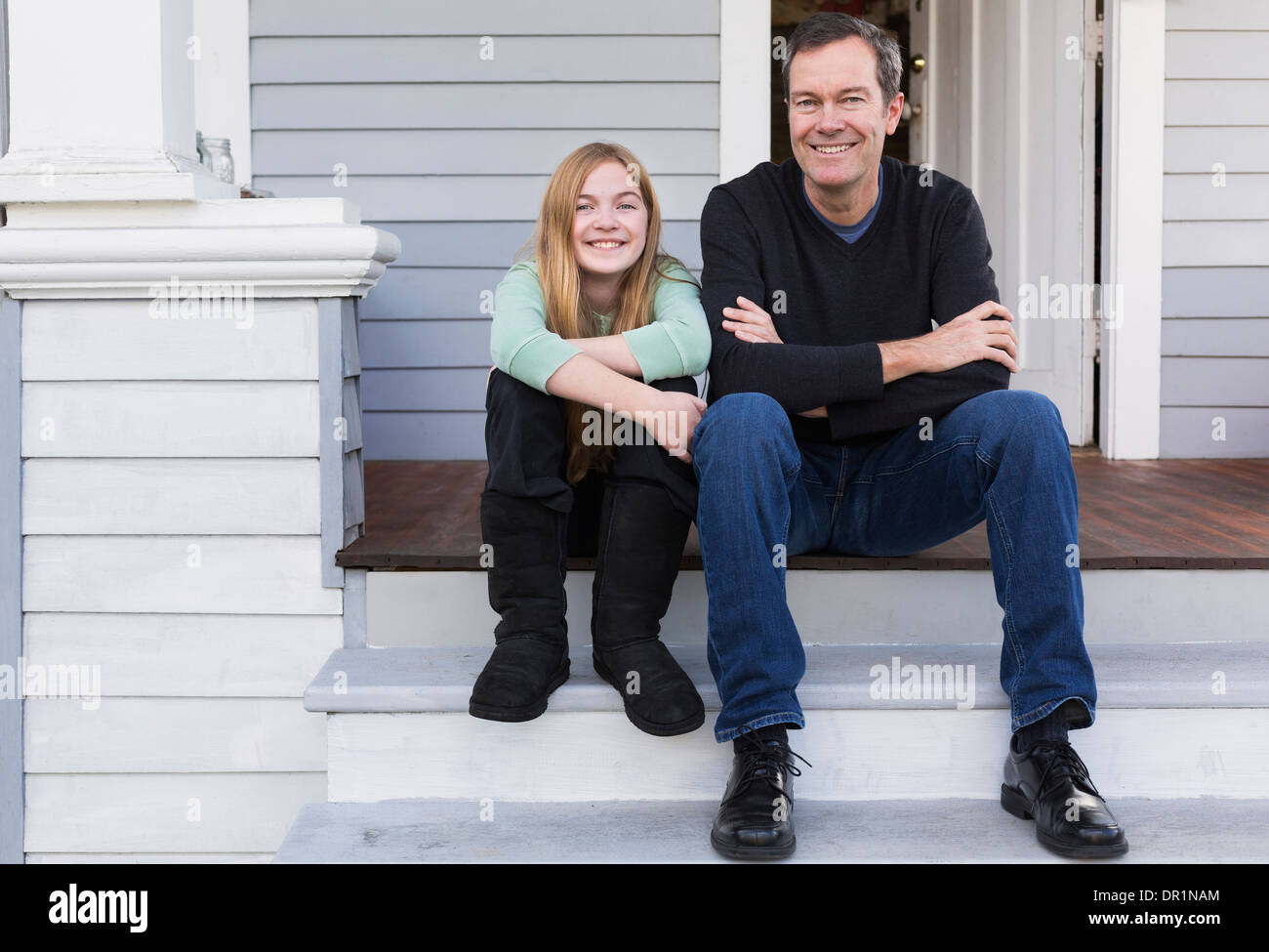 Caucasian father and daughter smiling on steps Stock Photo