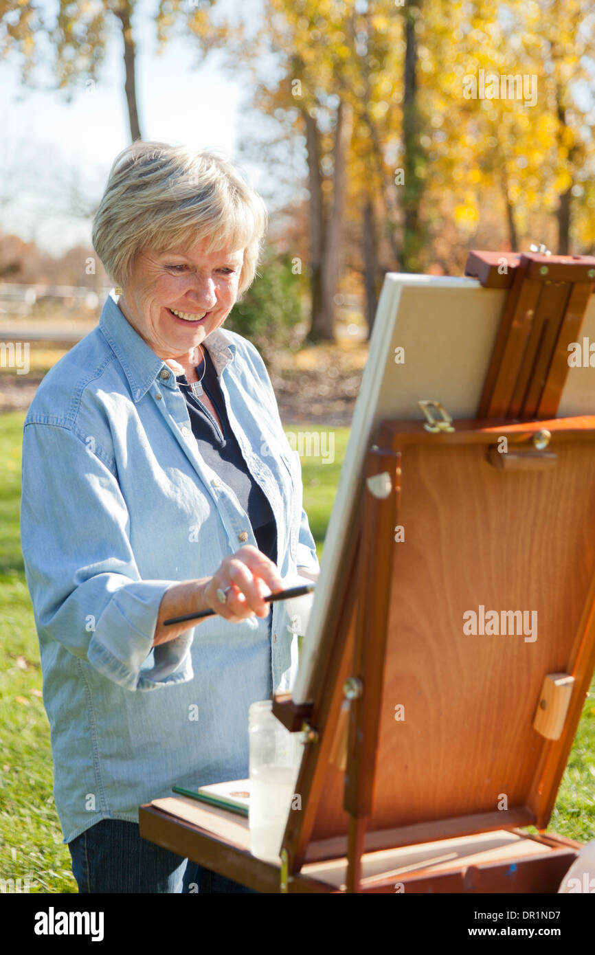 Senior woman painting outdoors Stock Photo