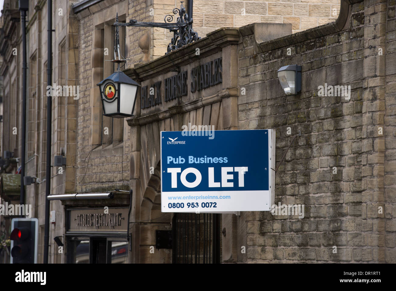 'Pub business To Let' sign on exterior wall of The Black Horse (traditional inn) in economic downturn - Otley, West Yorkshire, England, UK. Stock Photo