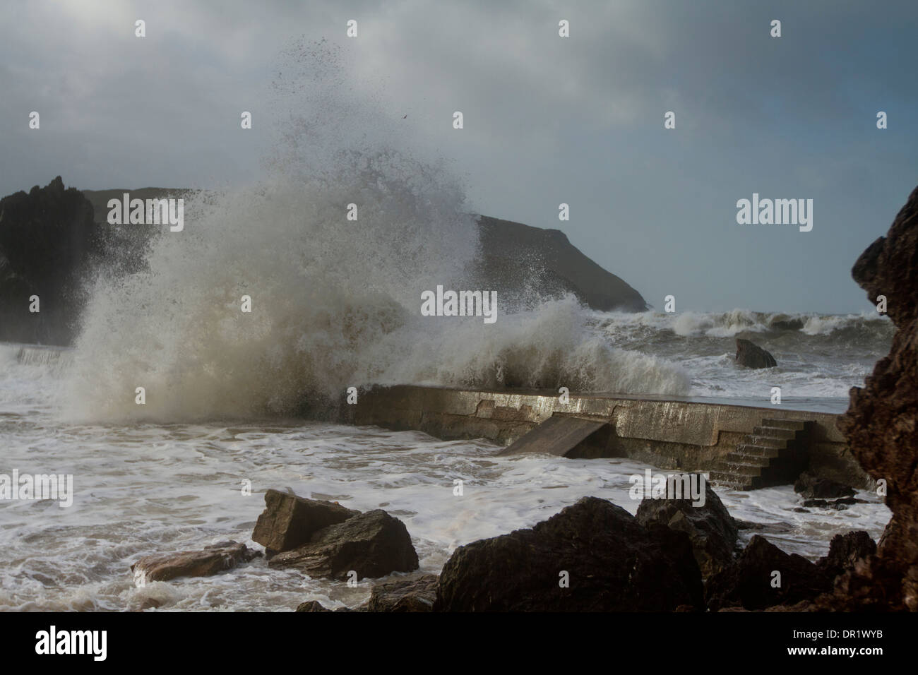 Stormy Seas at Hope cove crashing over sea wall Stock Photo