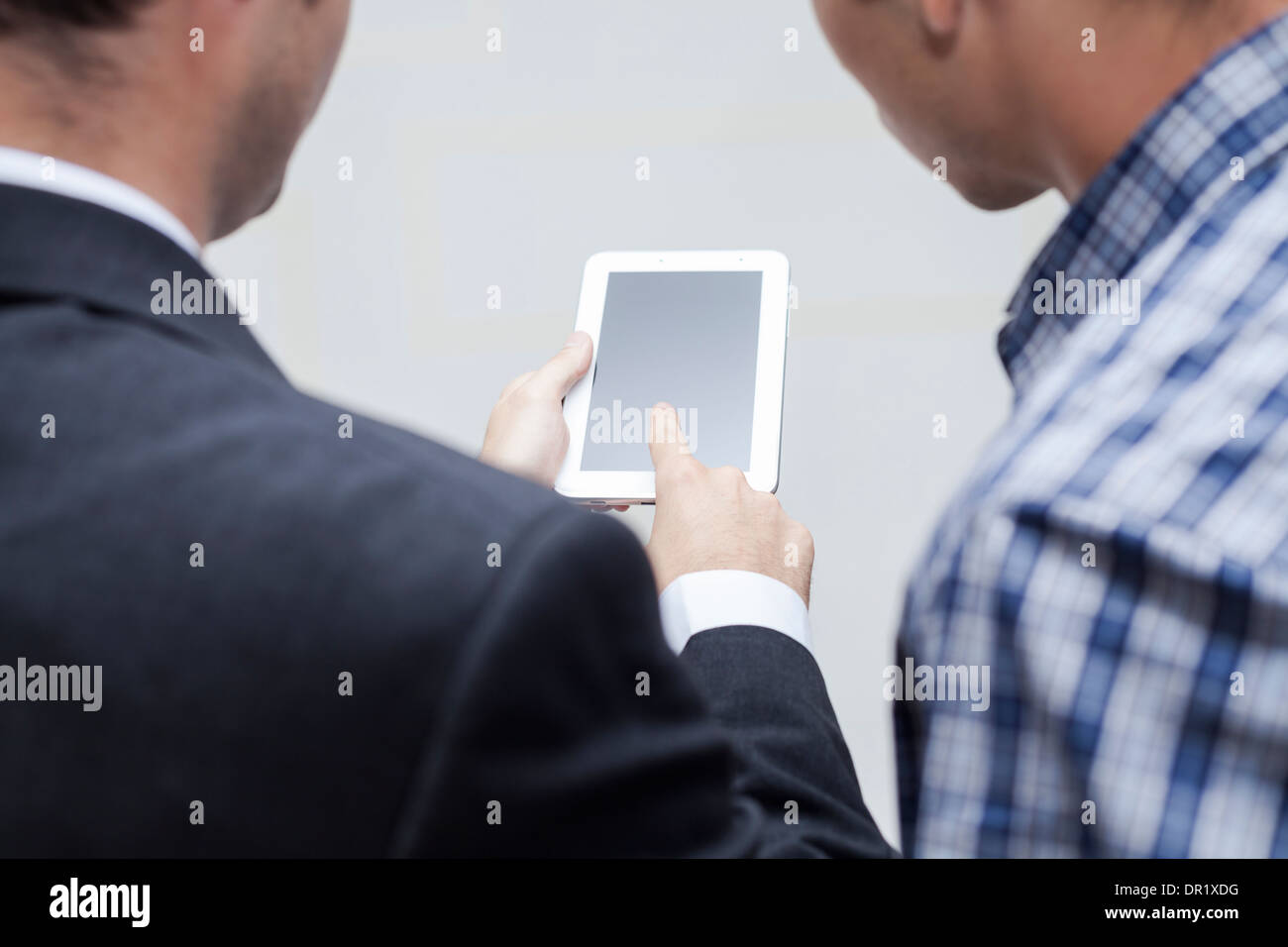 Detail of two businessmen using digital tablet. Stock Photo