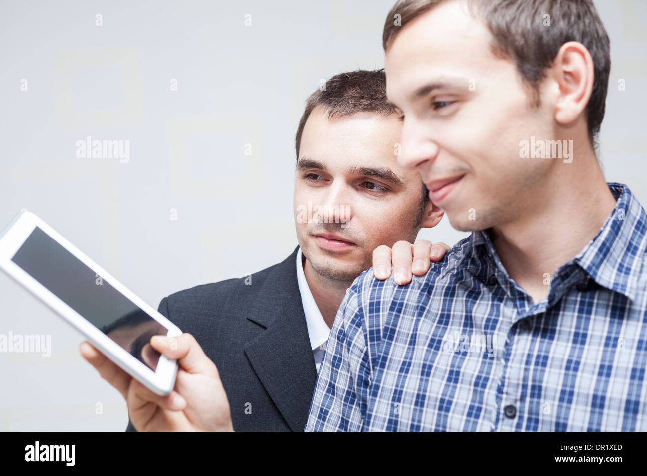 Two happy businessmen looking at digital tablet. Stock Photo