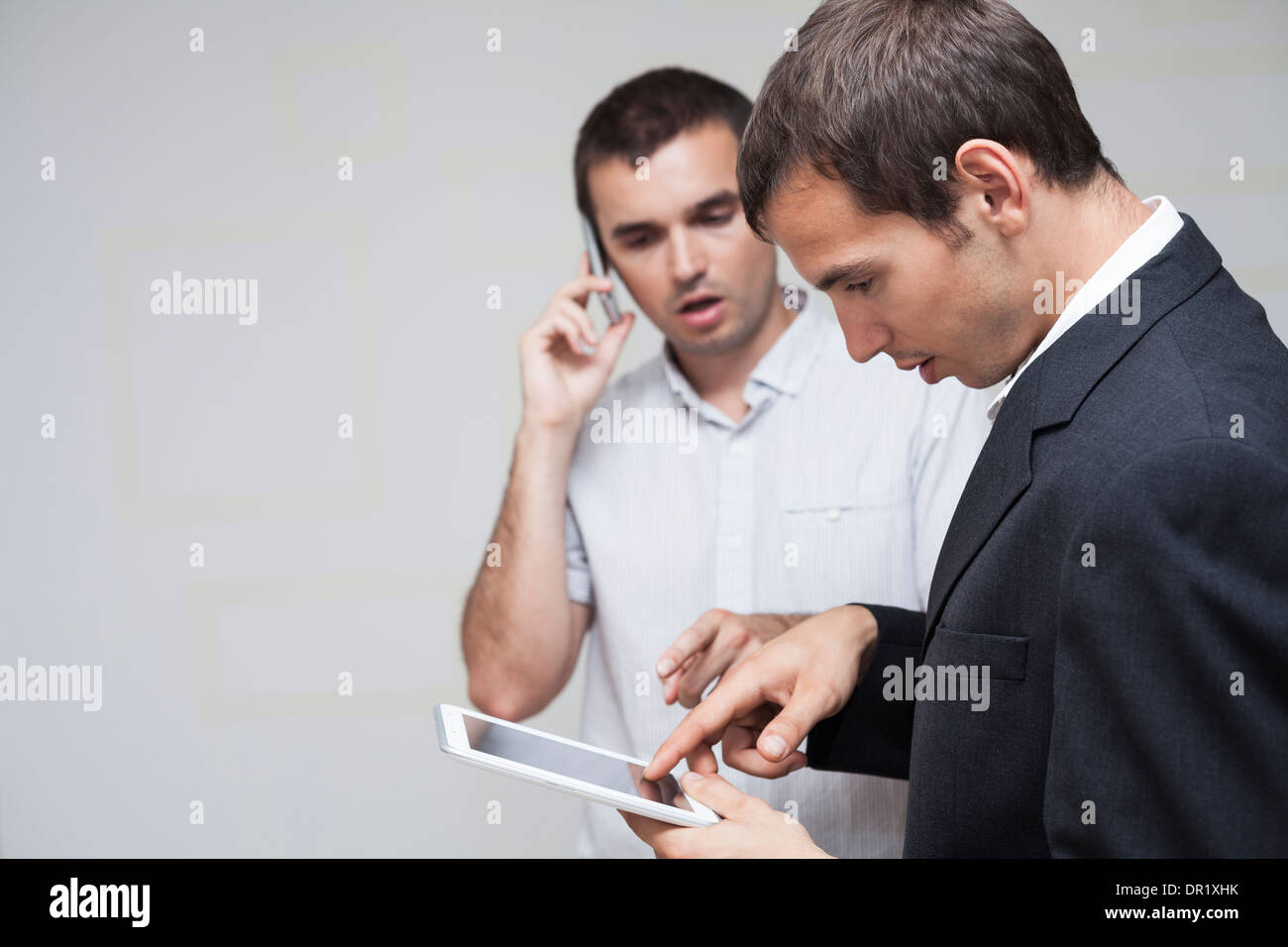 Two businessmen using digital tablet and smartphone. Stock Photo