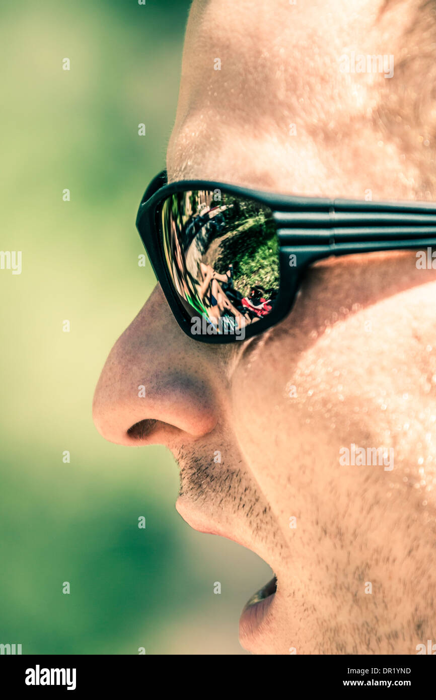 Detail of man face with open mouth wearing sport sunglasses Stock Photo