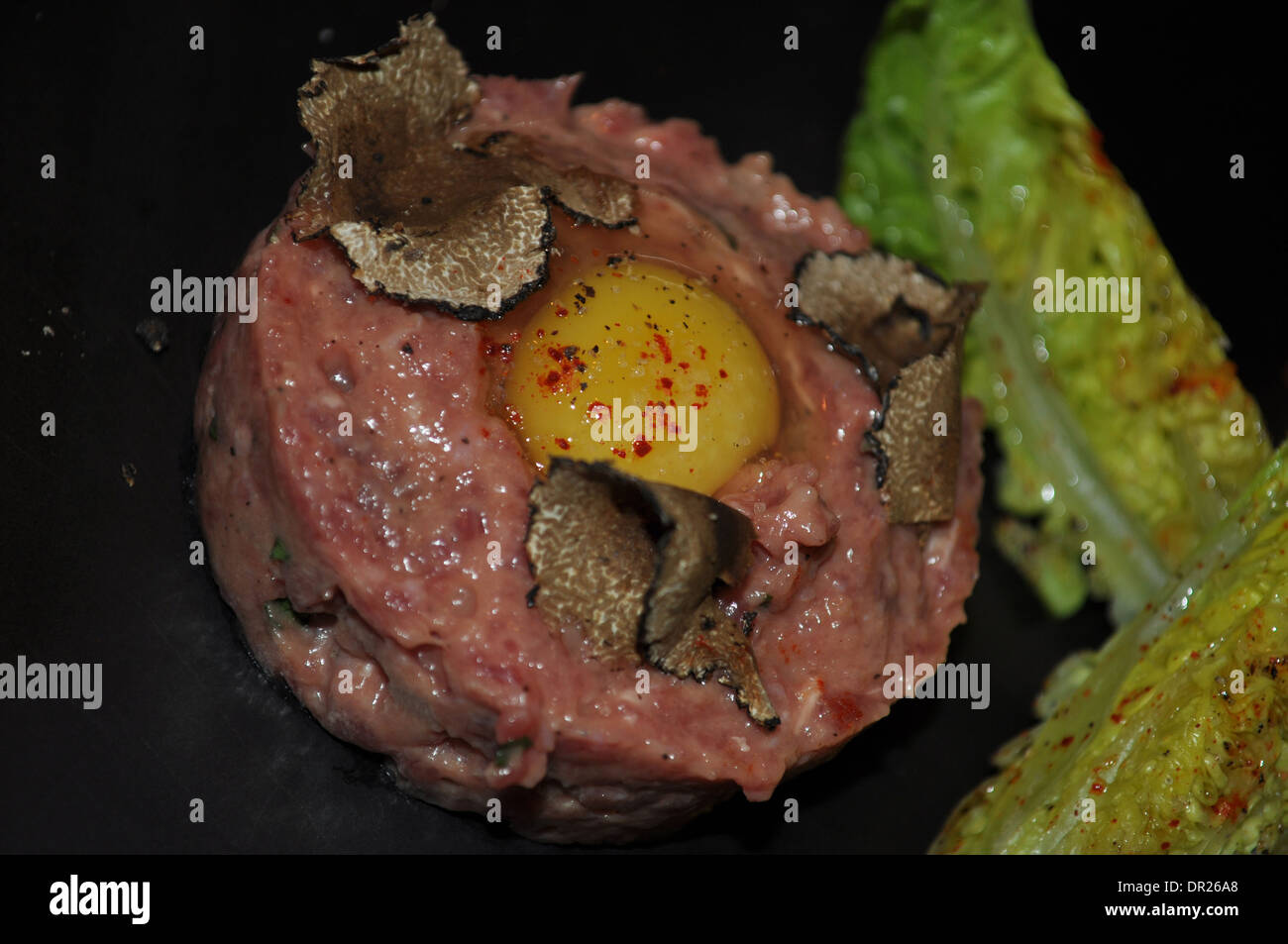 Steak tartare with shaved truffle served at a Michelin starred restaurant in London served on black slate Stock Photo