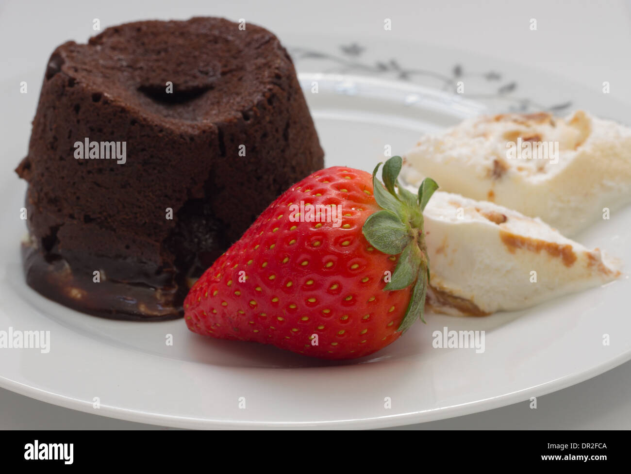 Chocolate cake volcano with creamy ice cream and strawberries Stock