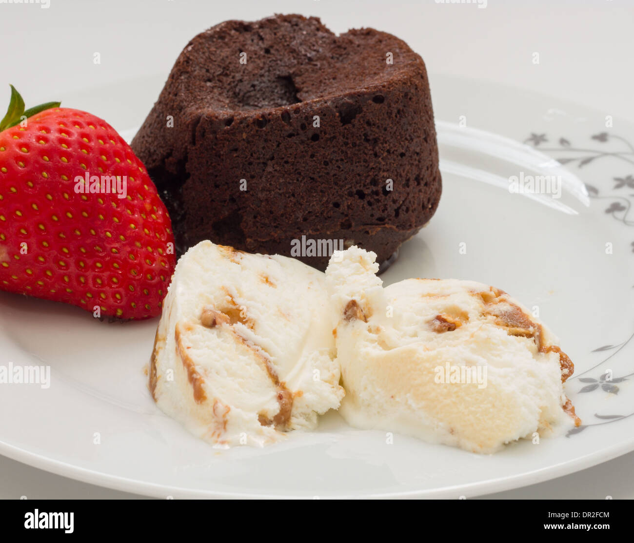 Chocolate cake volcano with creamy ice cream and strawberries Stock