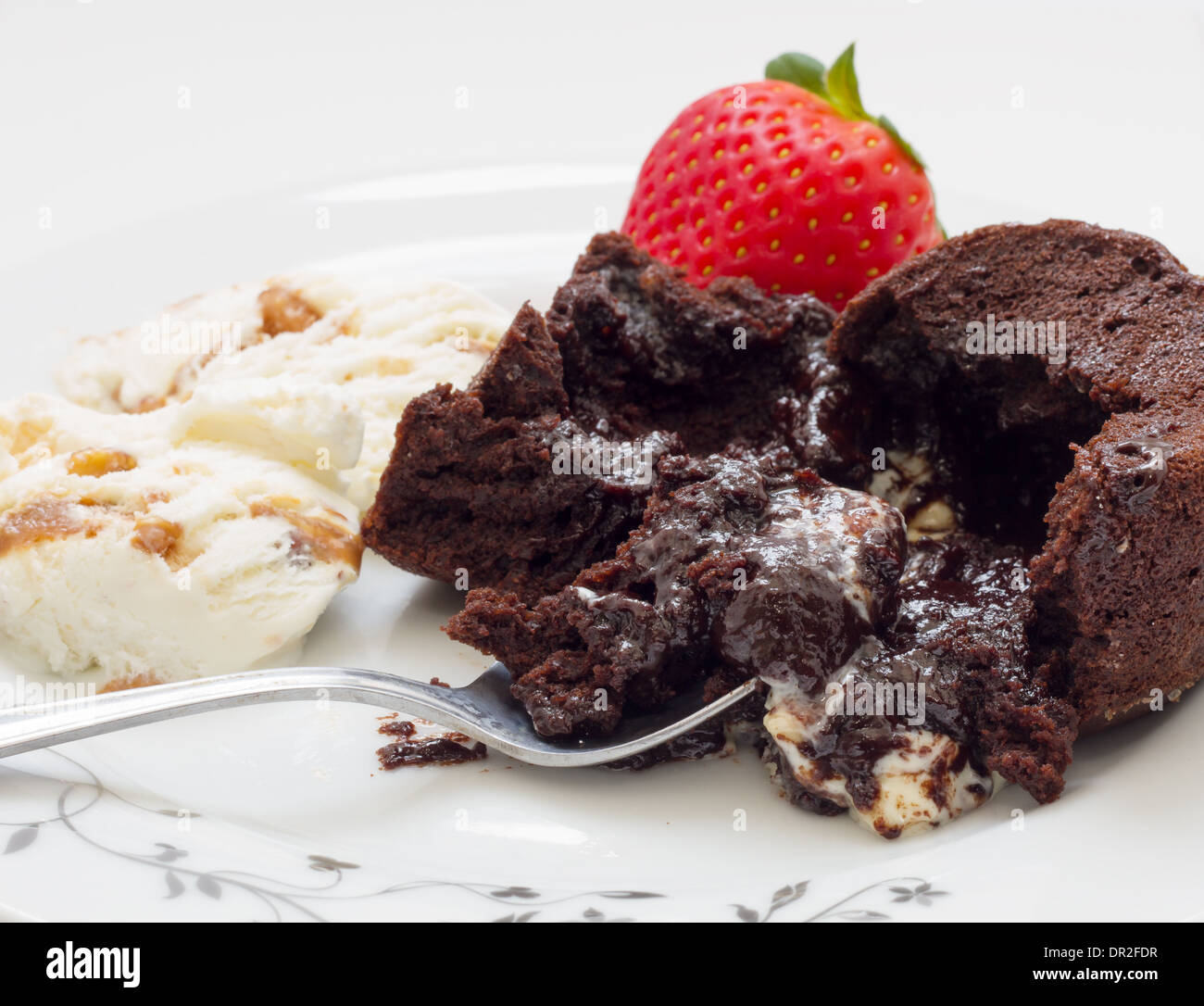 Chocolate cake volcano with creamy ice cream and strawberries Stock