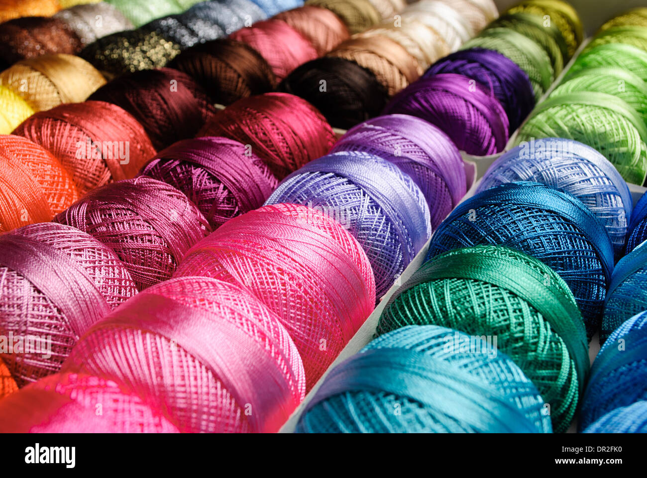 Different color threads on rows in the store Stock Photo - Alamy