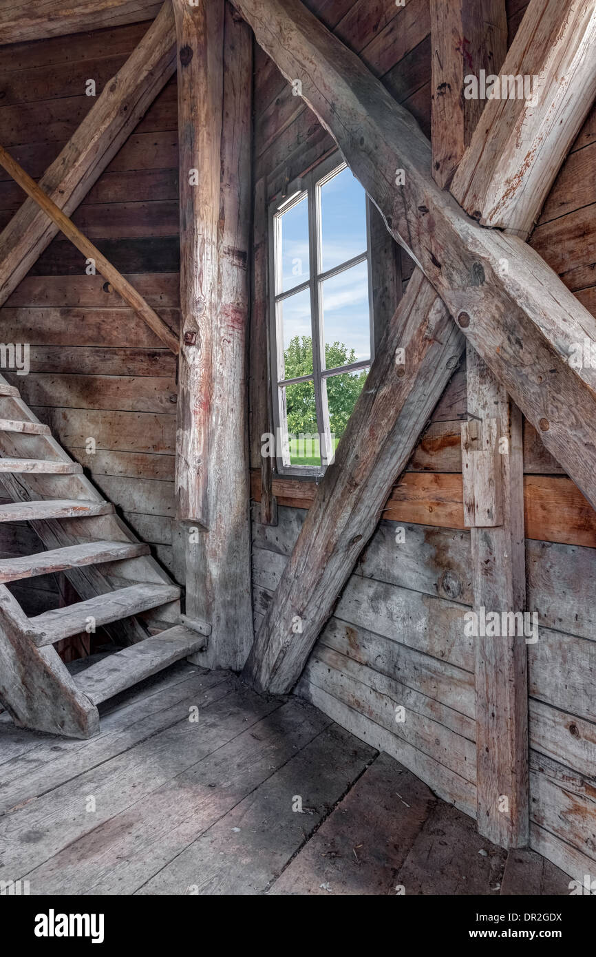 Interior of an abandoned wooden house with staircase and view over green garden. Stock Photo