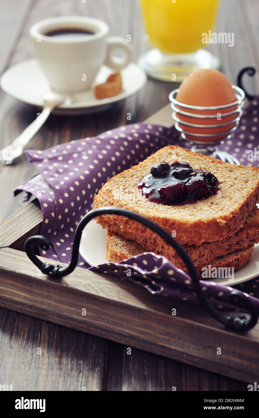 Breakfast with toast, fruit jam, boiled egg and coffee on tray Stock