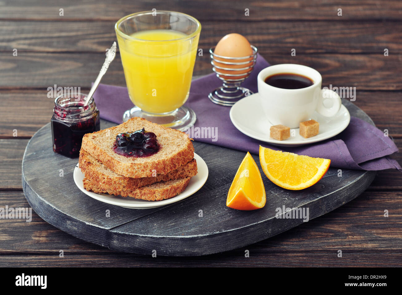 Breakfast with toast, fruit jam, orange juice and coffee on tray Stock