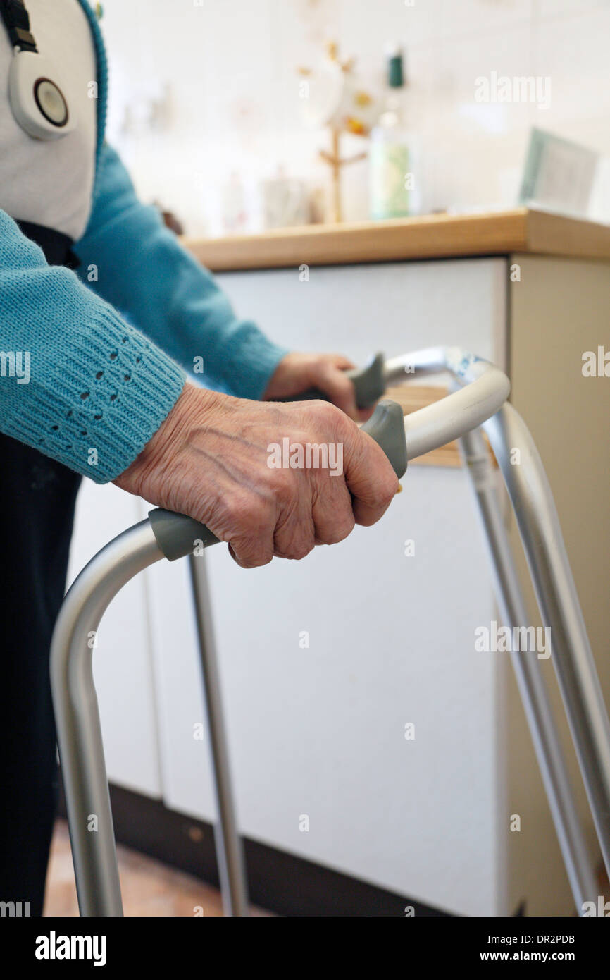 Old lady walking with the aid of a walking frame and wearing a personal