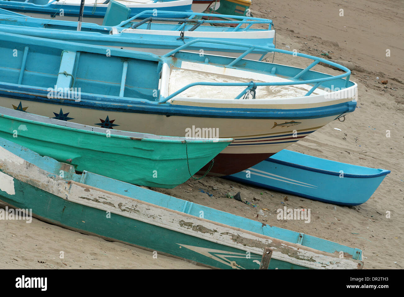 A wooden fishing boat pulled onto the sand covered beach at Puerto Lopez, Ecuador Stock Photo