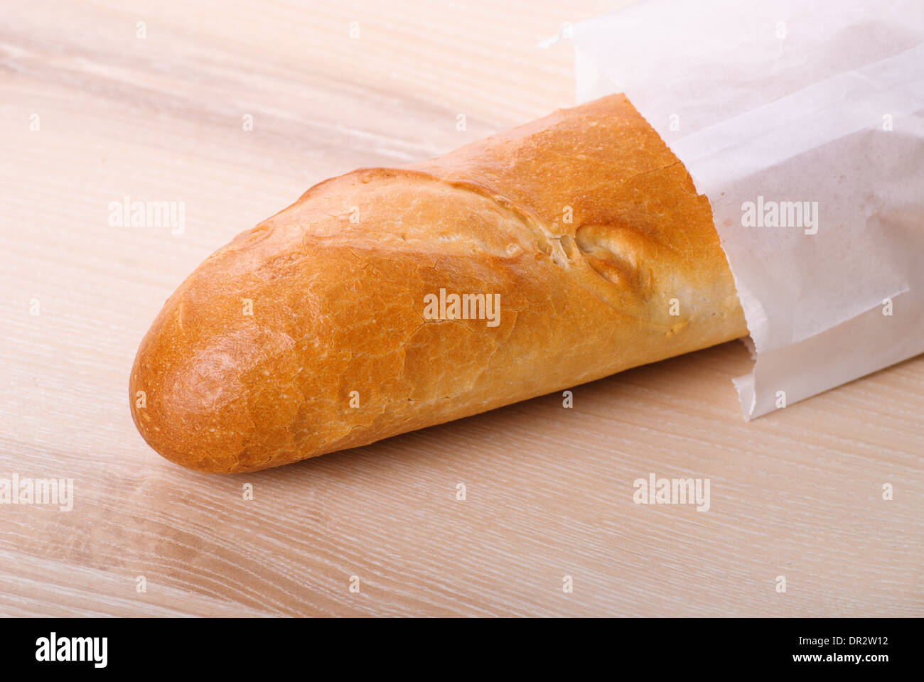 Long Loaf French Bread Packed In Paper On Table Stock
