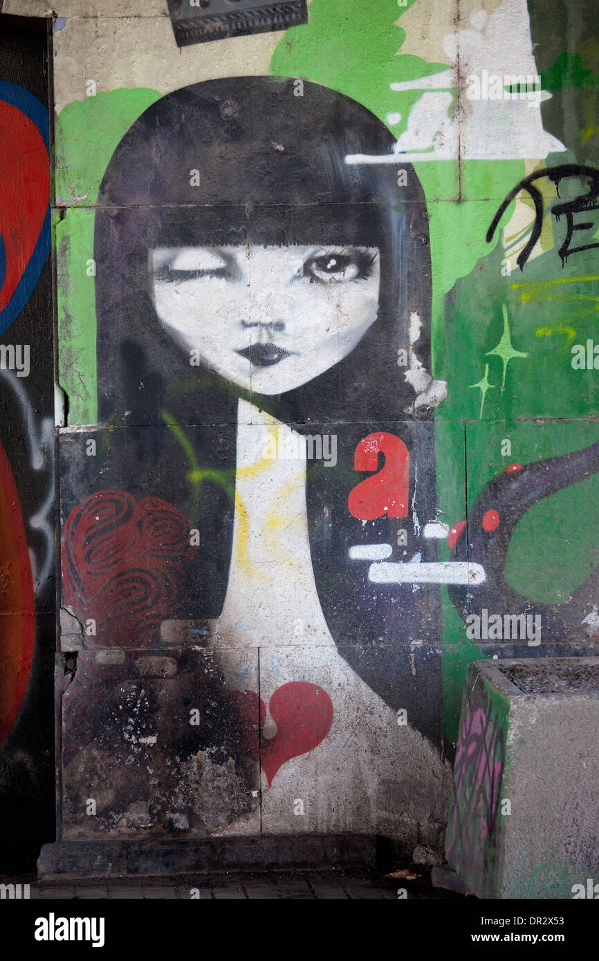 Girl with black hair blinking eye graffiti on a bridge wall in Seville, Spain. Stock Photo