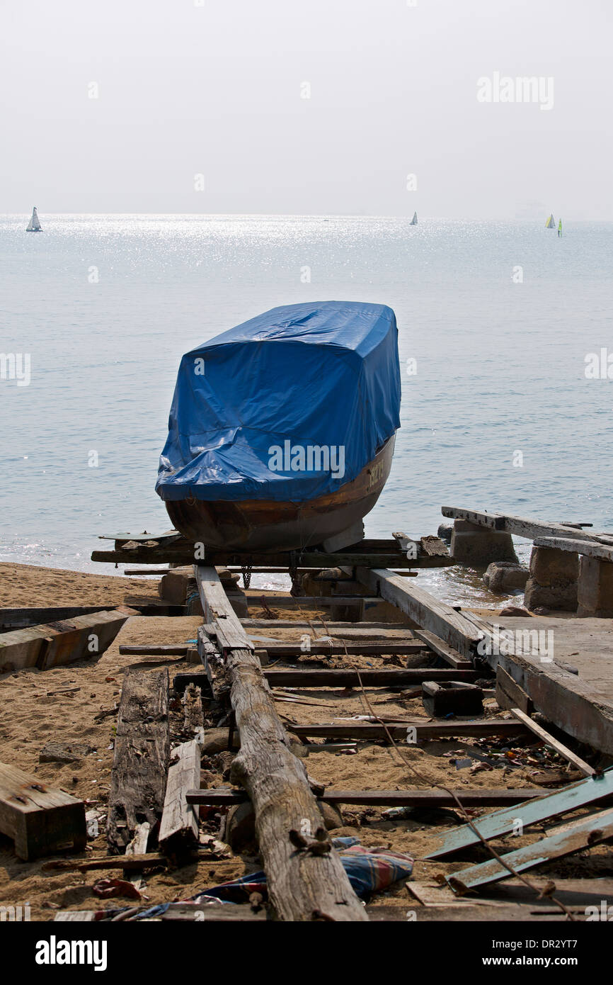Traditional Chinese Wooden Sampan sits on an old wooden slipway in Stanley, Hong Kong. Stock Photo