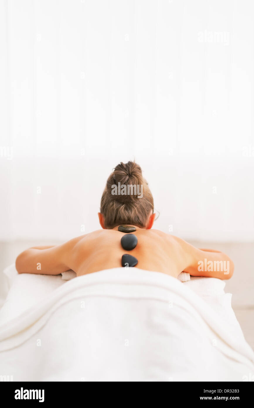 Young woman receiving hot stone massage. rear view Stock Photo