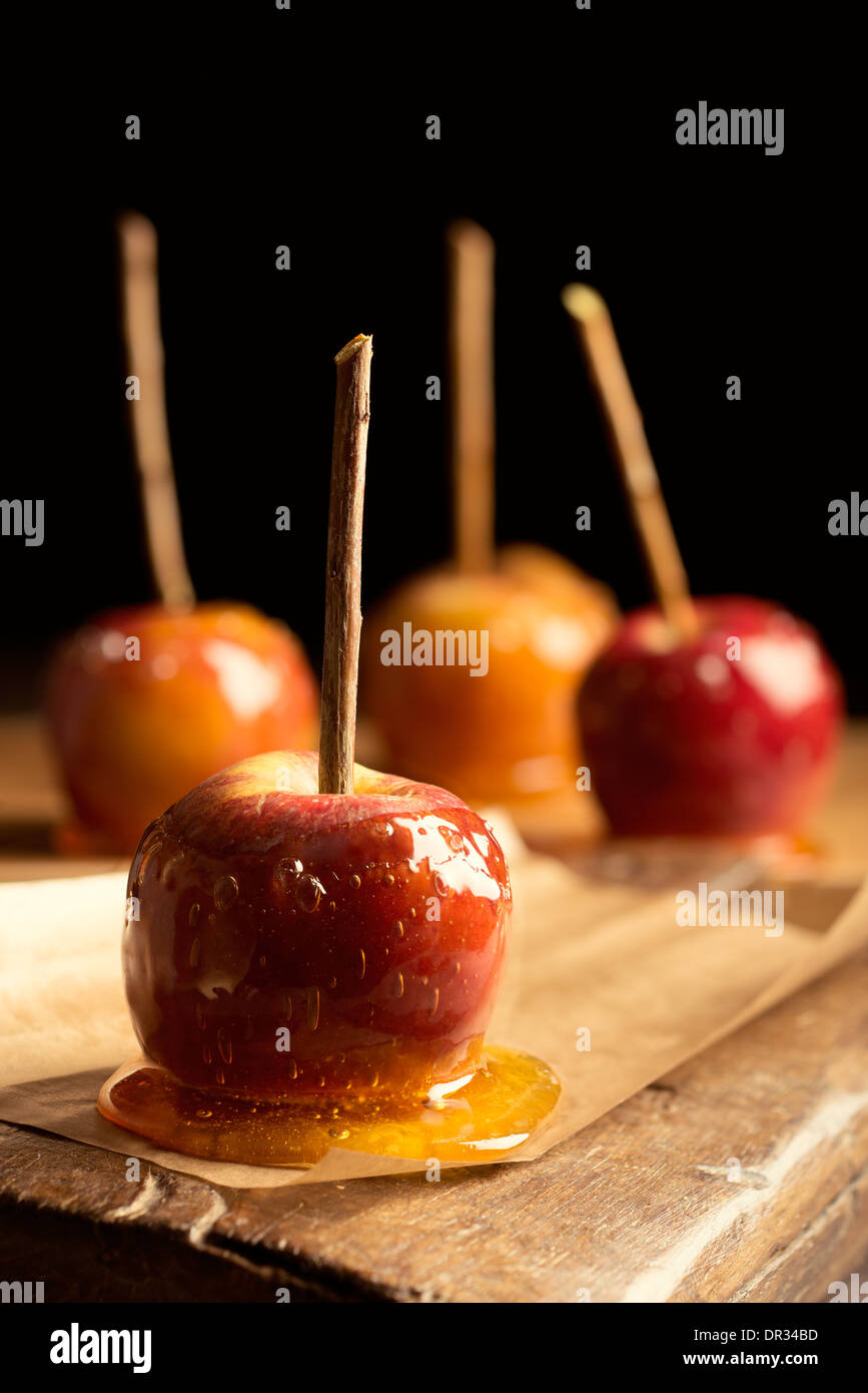 Close up of toffee apples on rustic board Stock Photo
