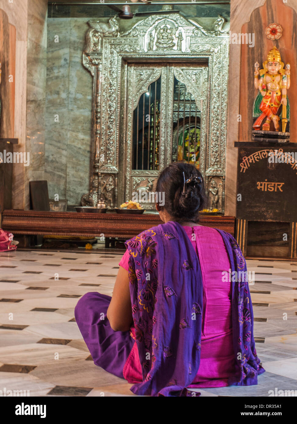 Woman seated on the floor in Hindu temple Stock Photo