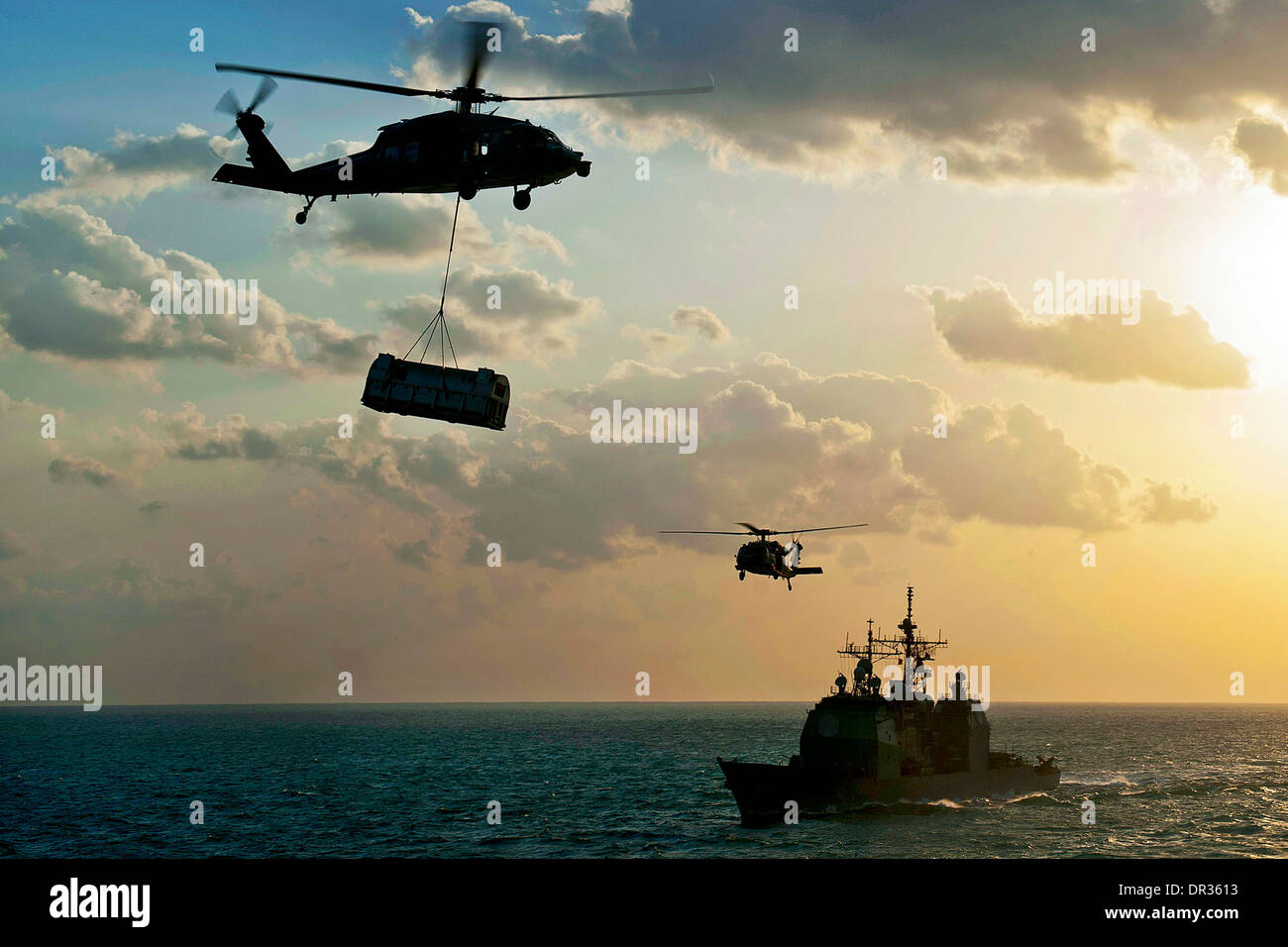 Sea Hawk helicopter transports supplies over the guided-missile cruiser USS Gettysburg Stock Photo