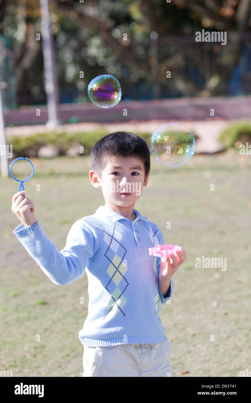 Boy blowing bubbles Stock Photo