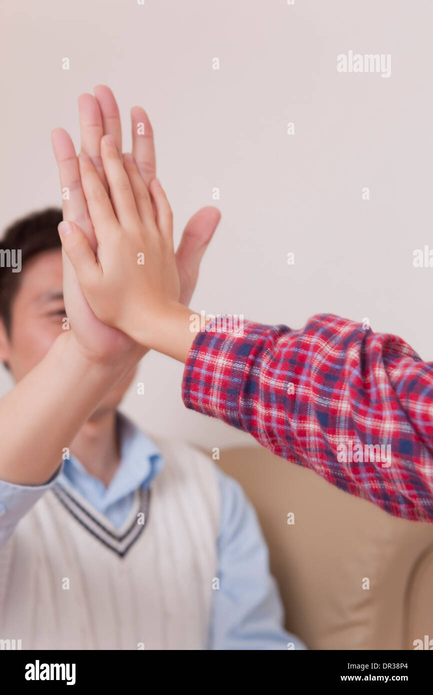 Father and son giving each other high five Stock Photo