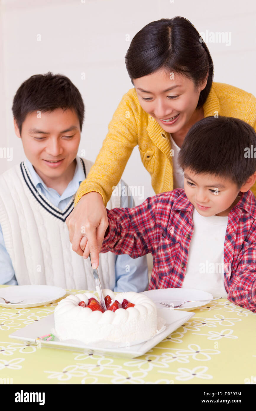 Mother and son cutting birthday cake Stock Photo