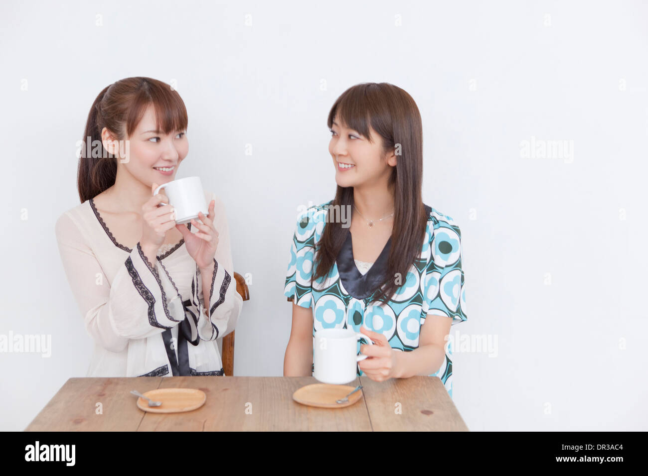 Two young women having hot drink Stock Photo