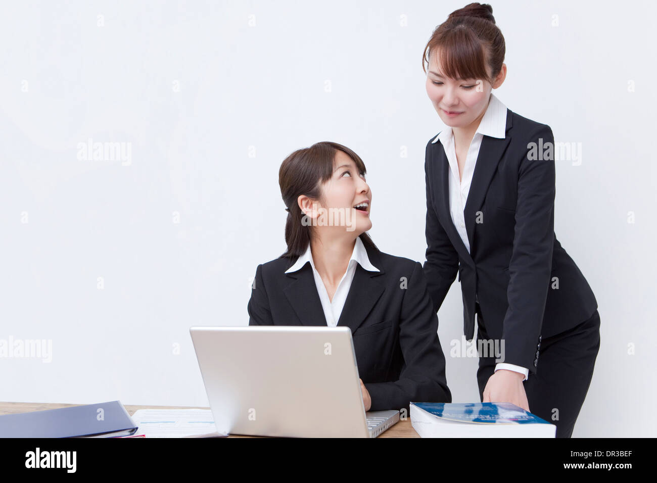 Two young business women using laptop Stock Photo
