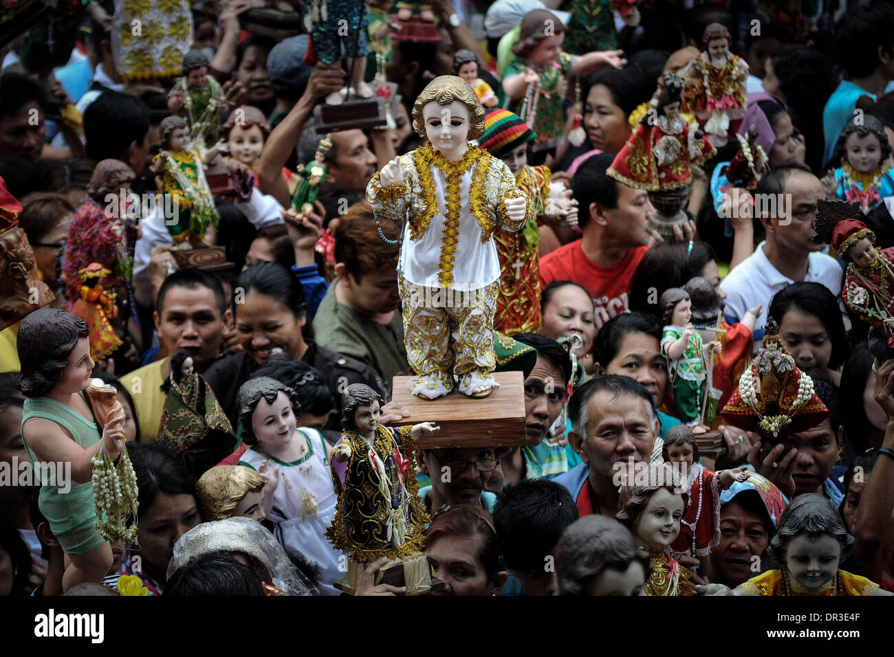 Manila, Philippines. 19th Jan, 2014. Filipino Catholics raise their Santo Nino statues before