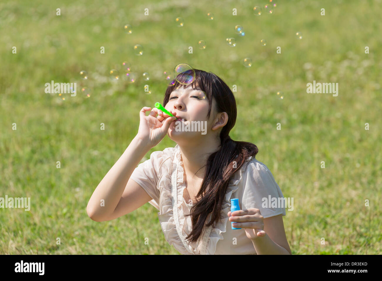 Young woman playing with bubble wand Stock Photo