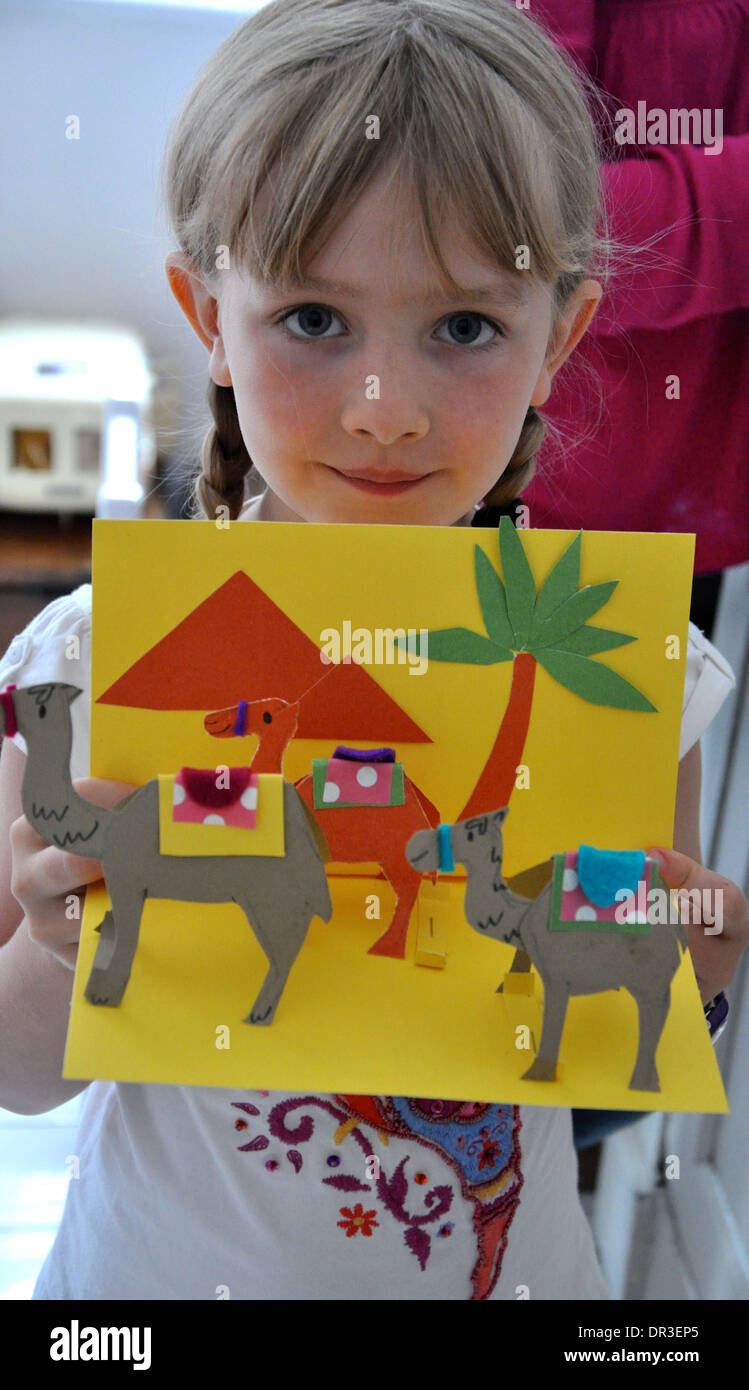 portrait of pretty little blonde girl showing off her project on Egyptian history for her school homework Stock Photo