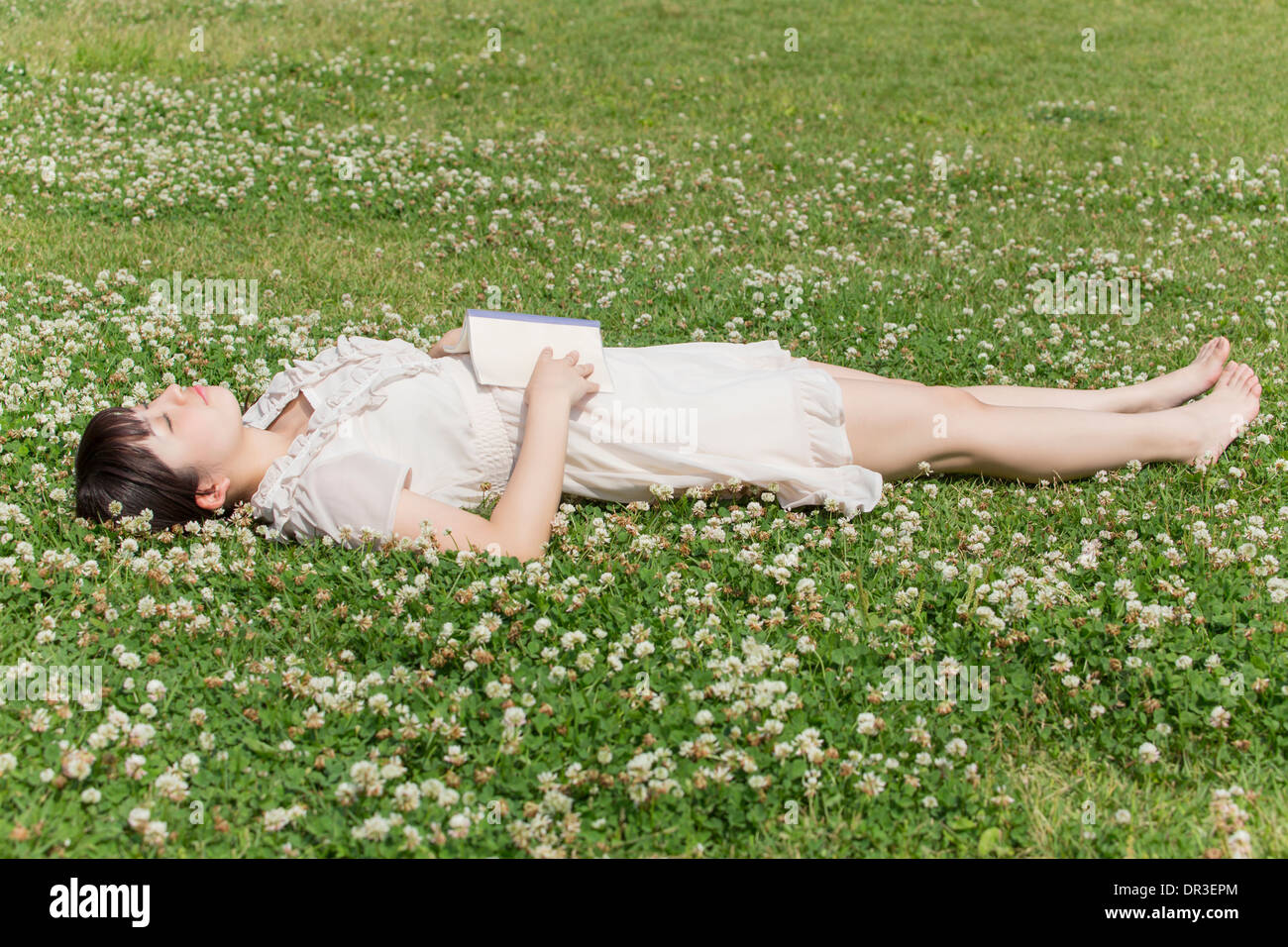 Young woman lying on grass Stock Photo - Alamy