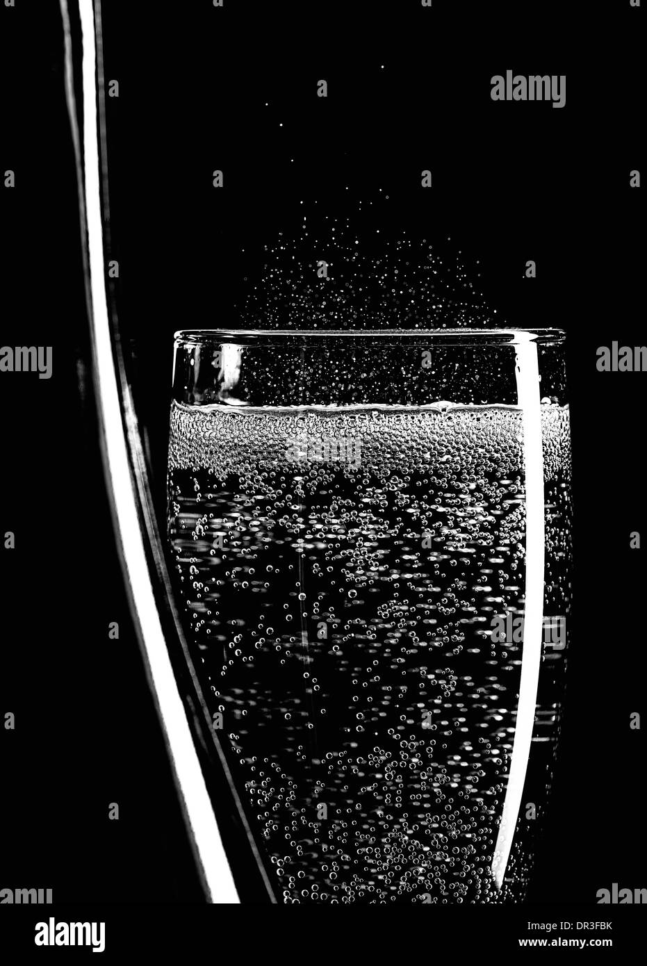 A champagne bottle and glass of sparkling wine, black and white image Stock Photo
