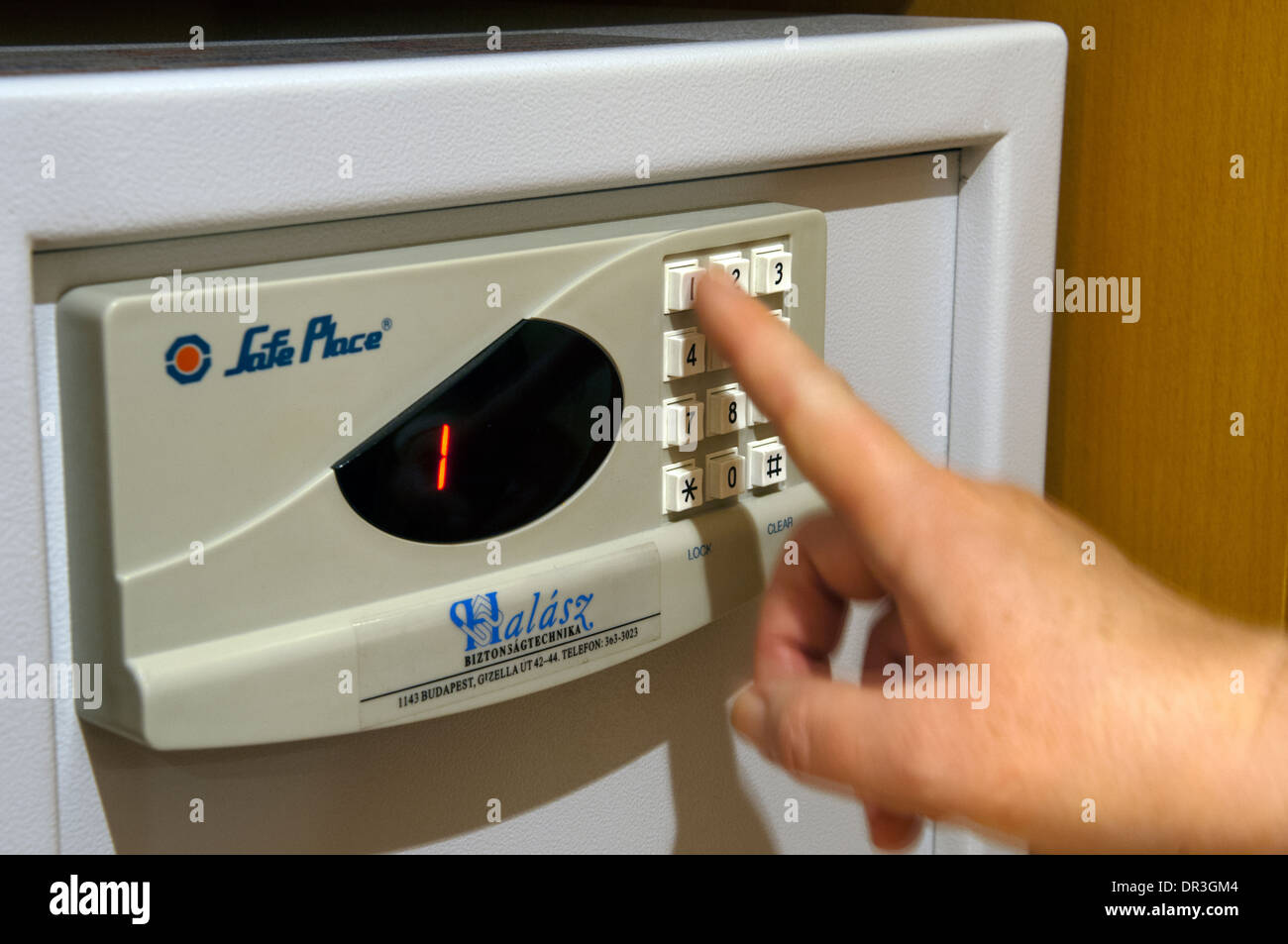 Female entering number code for hotel safe Stock Photo Alamy