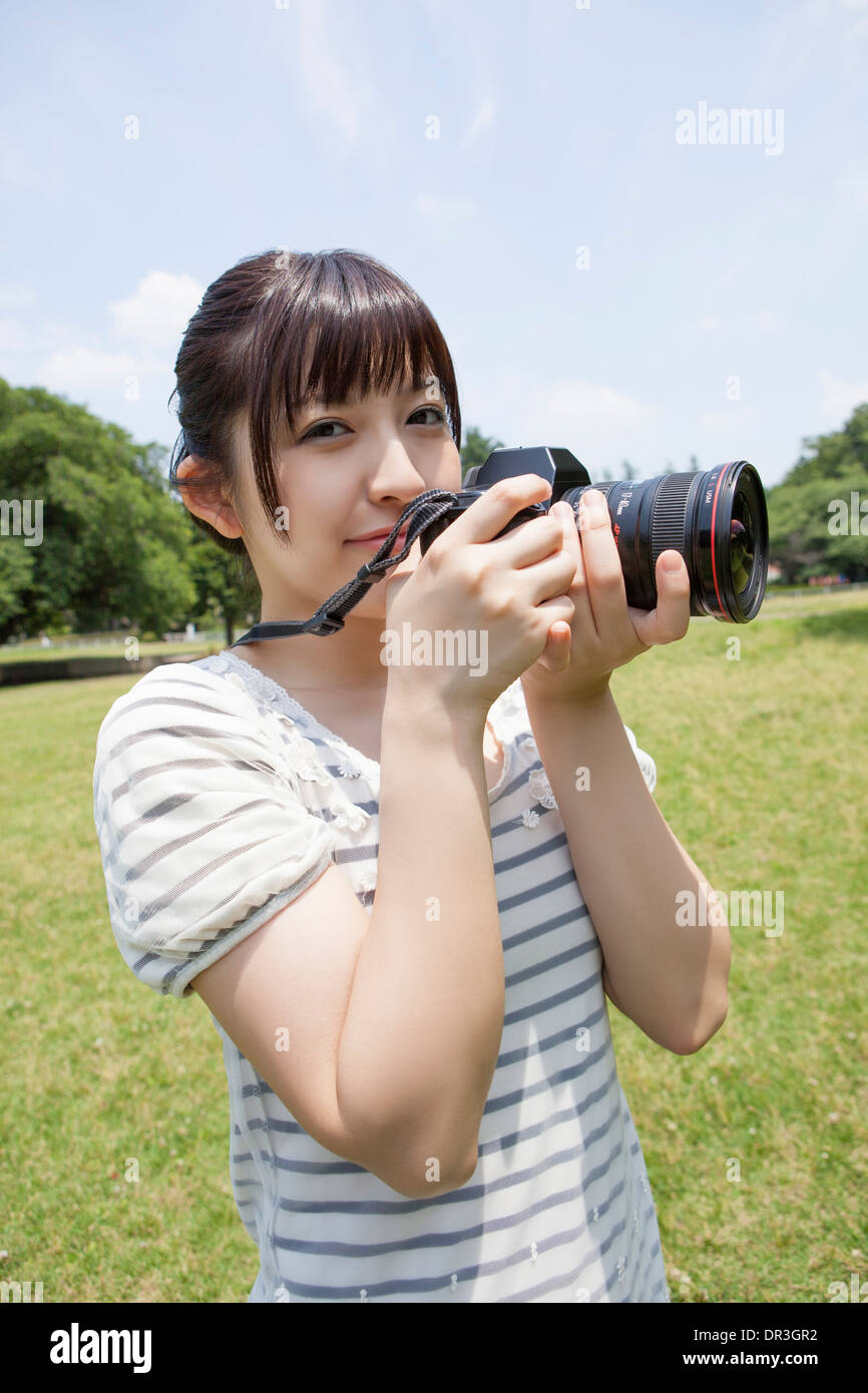 Young woman holding digital camera Stock Photo - Alamy