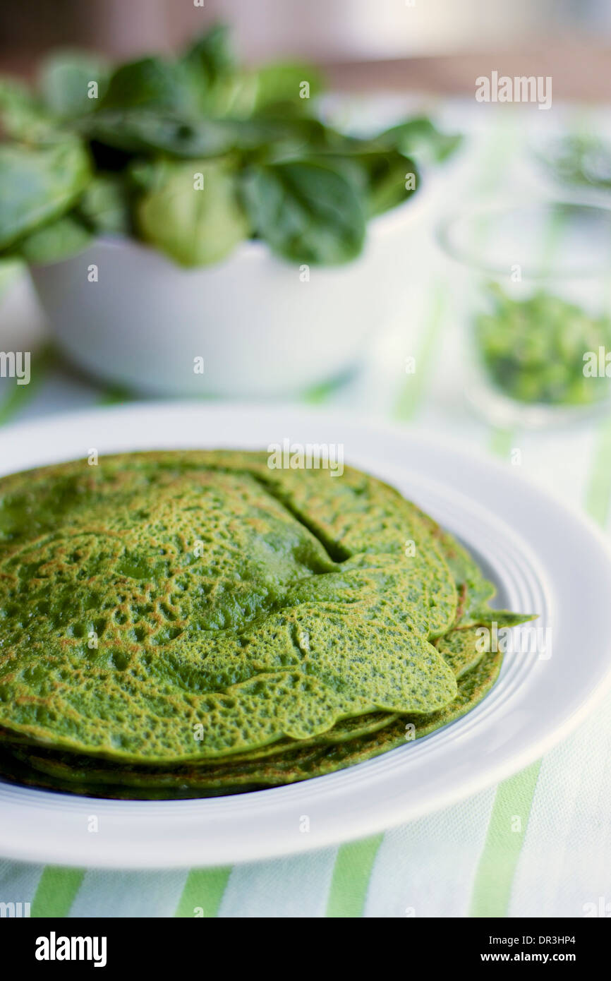 Stack of green pancakes on a plate. Stock Photo